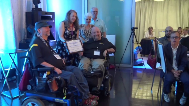 Gene and Dave receiving the The 2019 Lynn Marie Johnson Media Arts Award from Celia Hughes